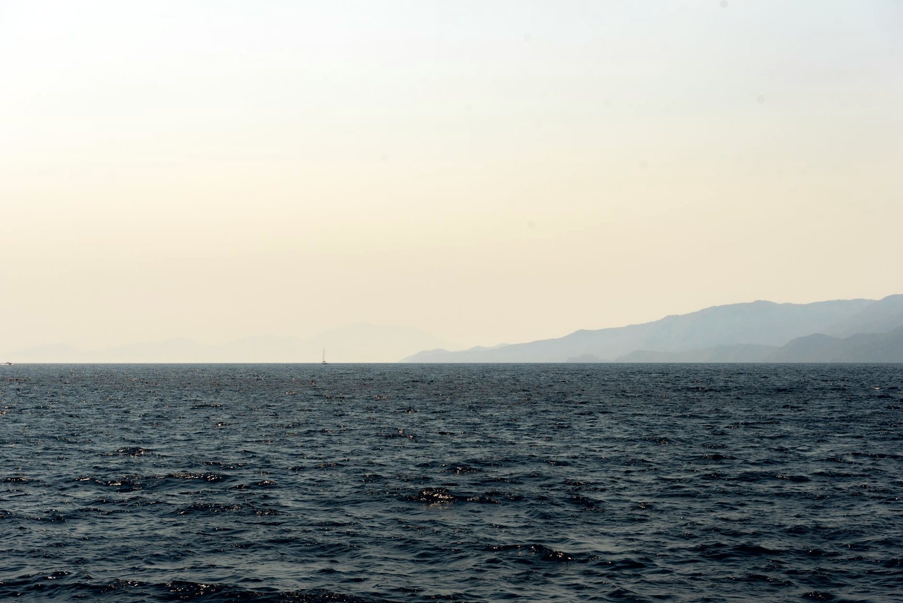 Mer calme et reliefs au loin